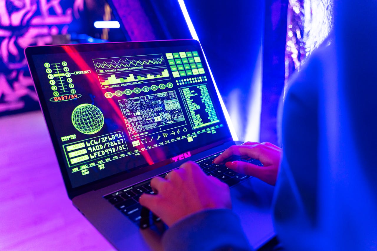 pexels-photo-5475750 Person typing on a laptop with vibrant digital data display, highlighting cyber security.