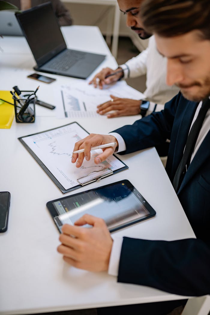 pexels-photo-7693743 Business professionals working with tablet and documents in a modern office.